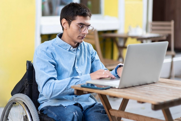 man on wheelchair using laptop