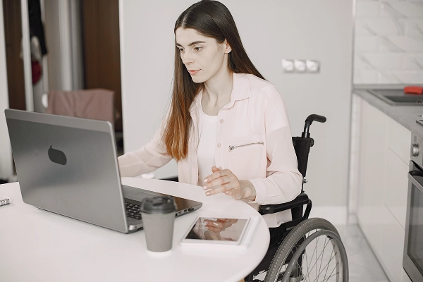 woman on wheelchair using laptop